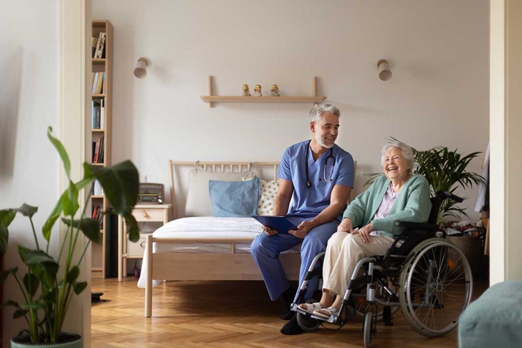 Resident choosing clothing with a caregiver in a bright, tidy assisted living room.